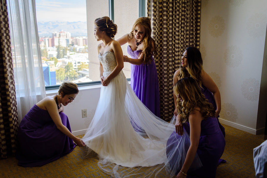 A bride being helped by her 4 bridesmaids