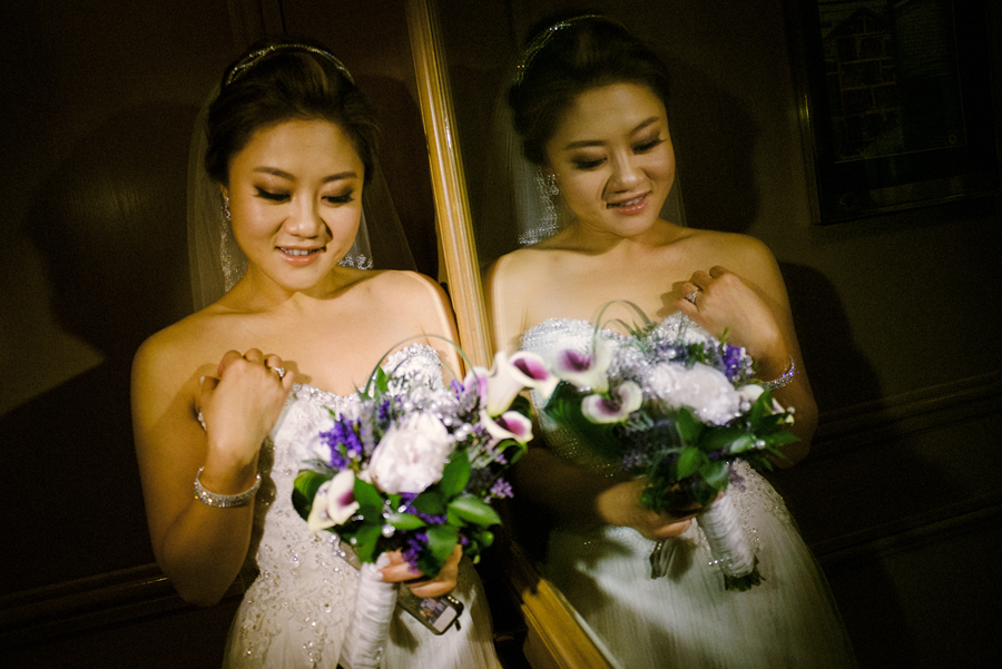 A bride photographed next to a mirror next to her own reflection