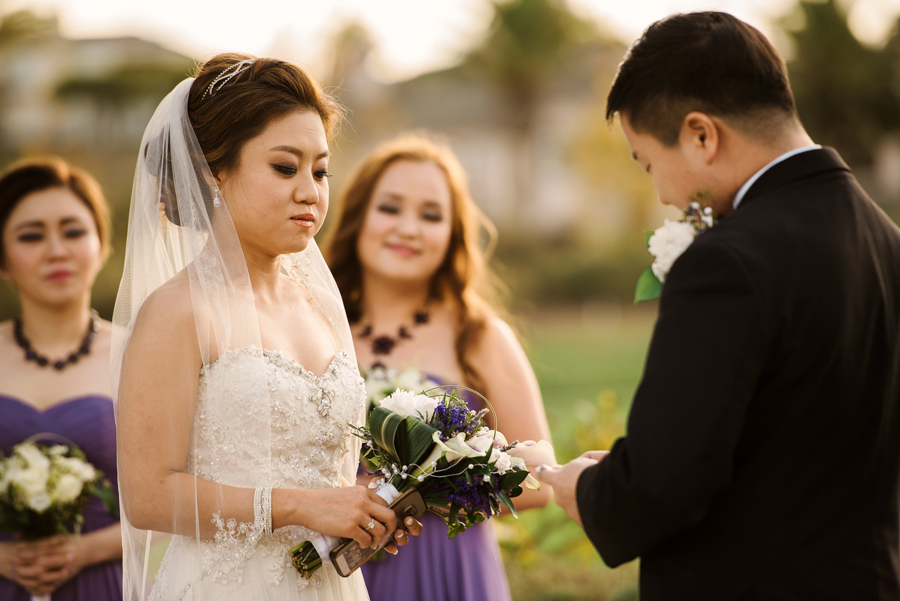 A bride holding her breath as the groom reads his line at their Wedding