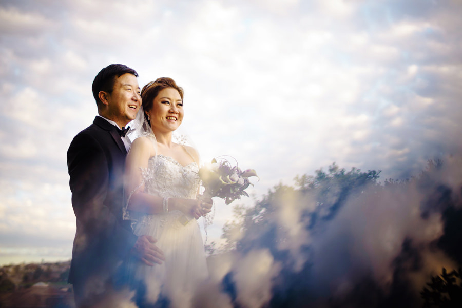 An artistic picture of a newly wed couple with the beautiful sunset cloud in the background