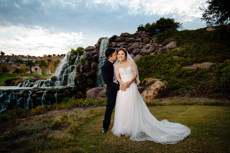 A newly wed couple poses in front of the Silver Creek fountain
