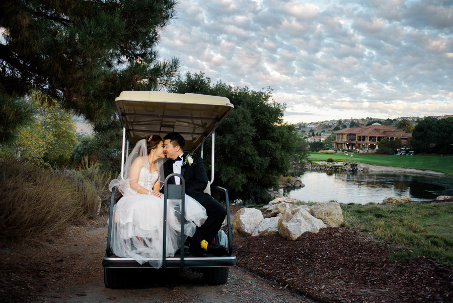 A couple kisses on a golf cart with the scenic view of silver creek as a background